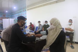 Satbrimob Polda Banten Membantu Memeriksa Kesehatan Masyarakat Yang Akan Divaksin